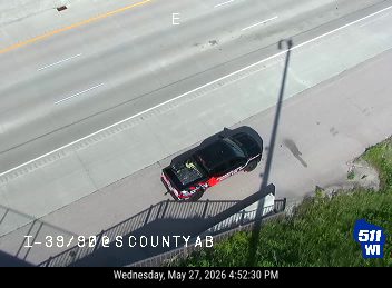 Police car stopped on the shoulder of the highway.