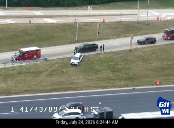 Ambulance, fire truck, and police car with lights on the roadway