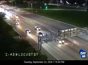 Tow truck and two police cars with lights on in the right lane
