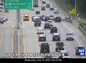 Emergency vehicle with flashing lights on the right shoulder of the highway.