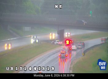 Emergency vehicle with flashing lights on the right shoulder of the highway.