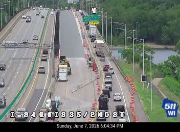 Emergency responders and traffic cones on the highway indicate an incident.