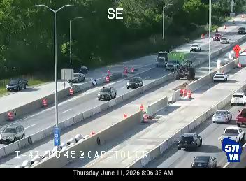 Emergency responders and equipment on the highway with traffic cones.