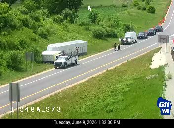 Emergency responders and vehicles are present on the roadside.