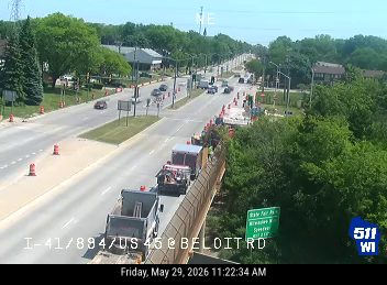 Construction vehicles and personnel are present on the roadway, indicating ongoing work.