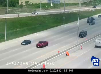 Emergency responder vehicle and cones on the shoulder of the highway.