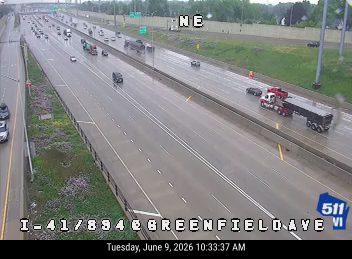 Emergency vehicles and a truck stopped on the right shoulder of the highway.