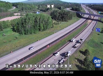 Emergency vehicles and a tow truck are stopped on the shoulder of the highway.