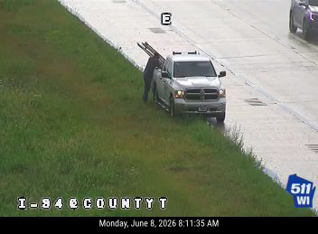 Person loading long objects from roadside into a pickup truck.