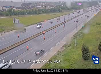 Emergency responders with cones on the highway, likely due to an incident.