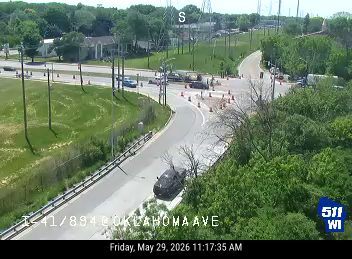Emergency responders and cones are present on the roadway, indicating an incident.