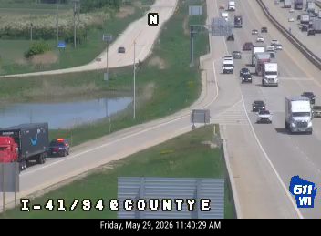 Police car and fire truck responding to an incident on the shoulder of the highway.