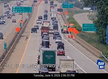 Emergency responders and traffic cones on the highway indicate an incident.