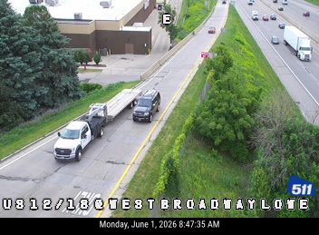 Emergency responders and vehicles are stopped on the shoulder of the highway.