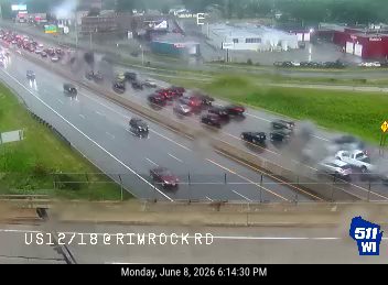 Heavy smoke billowing from vehicles on a multi-lane highway during daytime.