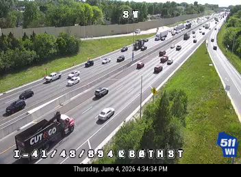 A fire truck and other vehicles are stopped on the shoulder of the highway.