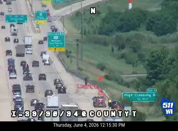 Emergency vehicle and cones on the highway shoulder, indicating a possible incident.