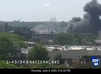Heavy smoke and flames visible from a building, indicating a fire incident.