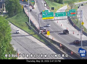 A fire truck is stopped on the shoulder with emergency lights on.