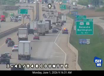 Police car with lights on in traffic, indicating a possible incident ahead.