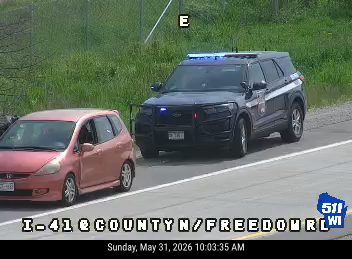 Police SUV with lights on at roadside, likely responding to an incident.
