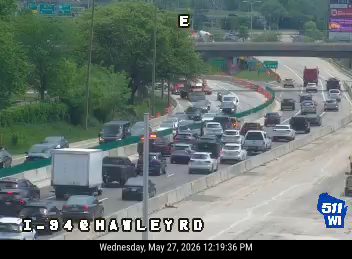 Emergency vehicles and construction equipment on the highway shoulder.