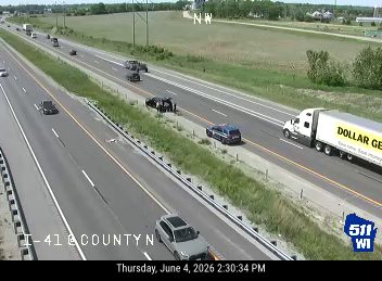 Two vehicles appear to be involved in a crash on the highway shoulder.