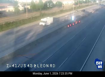 Emergency responders with cones and a vehicle on the roadway.