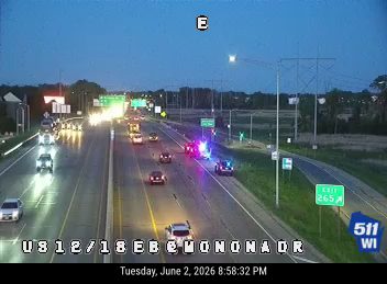 Emergency responders with flashing lights on the right shoulder of the highway.