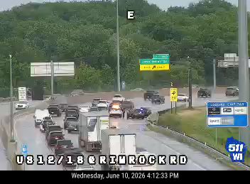 Emergency vehicle with lights on, traffic stopped on highway.