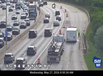 Two responders are present near a white truck on the side of the highway.