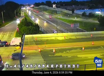 Emergency responders and cones on the highway, indicating a possible incident.