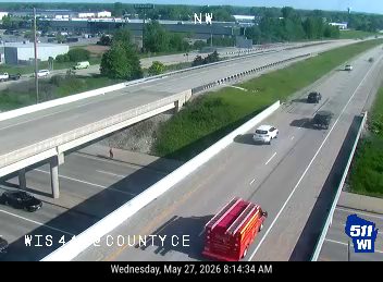 Fire truck on the side of the highway with emergency lights on-scene personnel.