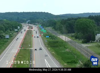 Construction barrels lining the left shoulder and lane of the left roadway