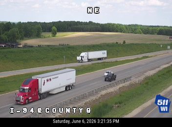 Tow truck and semi-truck stopped on the shoulder, possibly assisting with an incident.