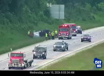 Emergency responders and vehicles at a crash scene on the roadside.
