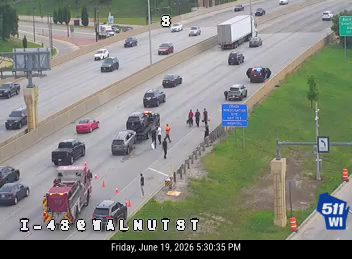 Fire truck and multiple people on the roadway near a tow truck