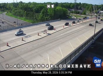 Emergency vehicle and cones on the roadway, indicating an incident.