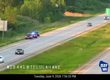 Police and emergency vehicles on the roadside with flashing lights.