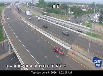 Red car stopped on shoulder, appears to be a minor crash.