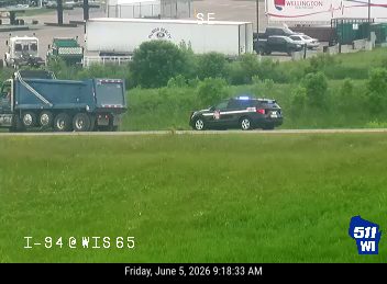 Police car with lights on, stopped on the side of the road.