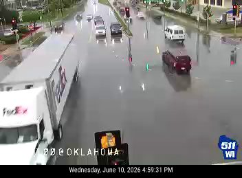 Roadway is flooded with standing water, affecting traffic flow.