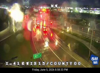 Emergency vehicles with flashing lights on the highway, likely responding to an incident.