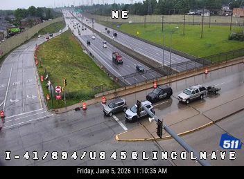 Police and other vehicles are stopped on the highway, likely responding to an incident.