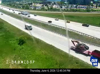 Large construction equipment on a trailer blocking the right lane.