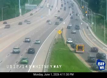 Emergency vehicles and a tow truck are stopped on the shoulder of the highway.