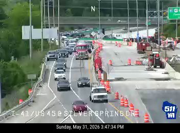 Construction vehicles and cones indicate ongoing work on the highway.