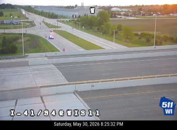Police car with lights on, stopped on the highway, likely responding to an incident.