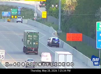 Police car and traffic control on highway, indicating an incident response.
