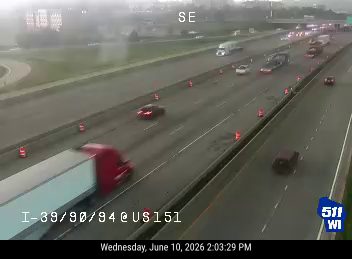 Emergency responders and cones on highway, traffic slowed.
